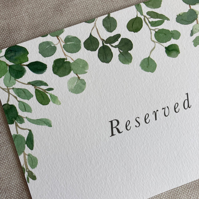 Reserved sign with green leaf design on a textured surface