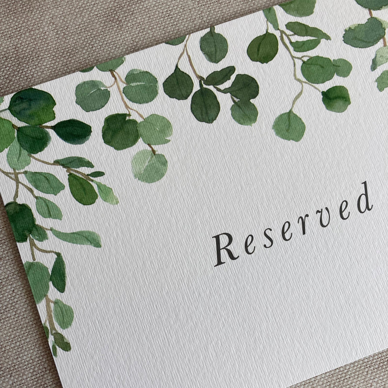 Reserved sign with green leaf design on a textured surface